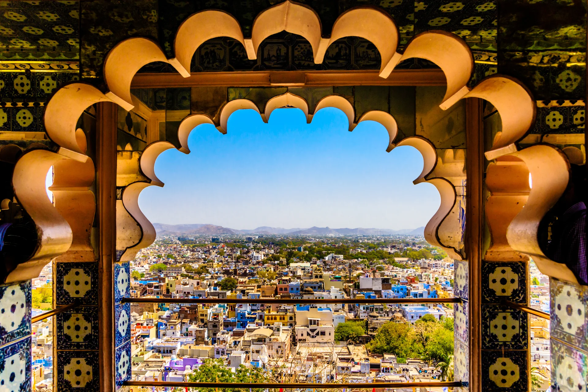 Udaipur City Palace through window — Rajasthan heritage filming location for international productions seeking palace-period coverage.